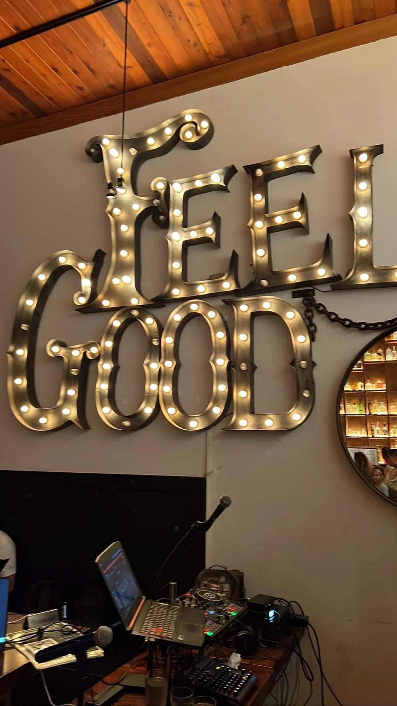 Real karaoke setup under a glowing Feel Good sign